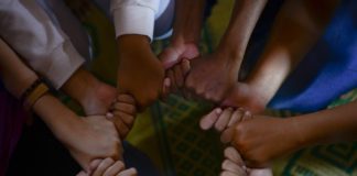 Image depicts interlocking hands to signify how UC empowers employees to communicate and collaborate effectively