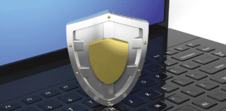 Silver shield symbol on laptop black keyboard.