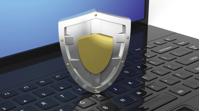 Silver shield symbol on laptop black keyboard.